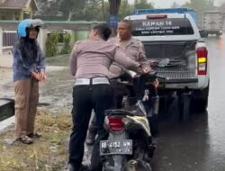 Ditengah Guyuran Hujan, Polisi Lalulintas Bantu Pengendara Motor Mogok di Jalinsum Way Kanan